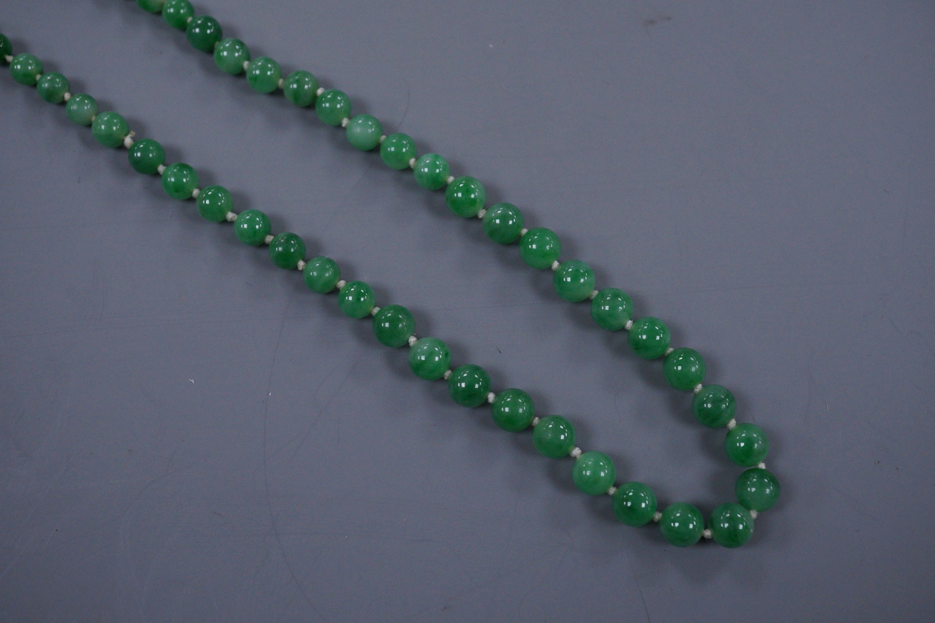 A graduated jade bead necklace with diamond set clasp stamped 9ct, 50cm